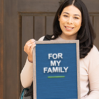 Female student holding sign that reads, "FOR MY FAMILY."